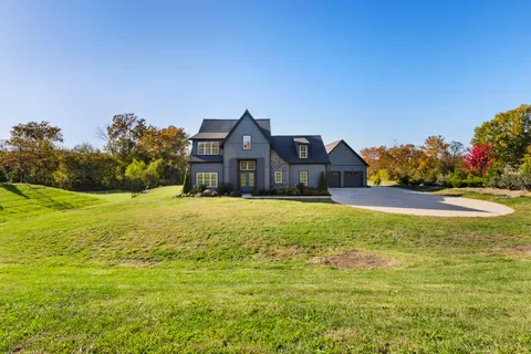a kitchen with stainless steel appliances granite countertop a table chairs a sink and a refrigerator
