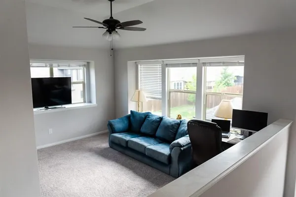 a living room with furniture tv and a window