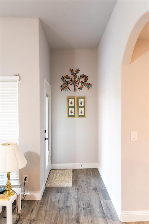 809 Woodview Court Anna, TX 75409 - Photo 20 of 25 a view of a hallway with a dining room and wooden floor