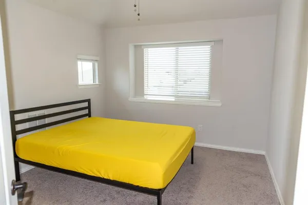 a blue bed sitting in a bedroom next to a window