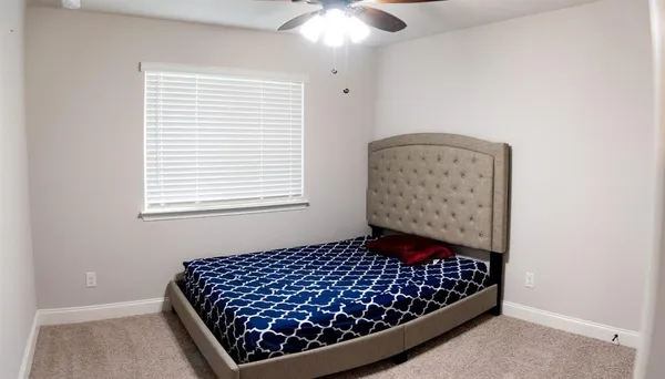 a bed sitting in a bedroom next to a window