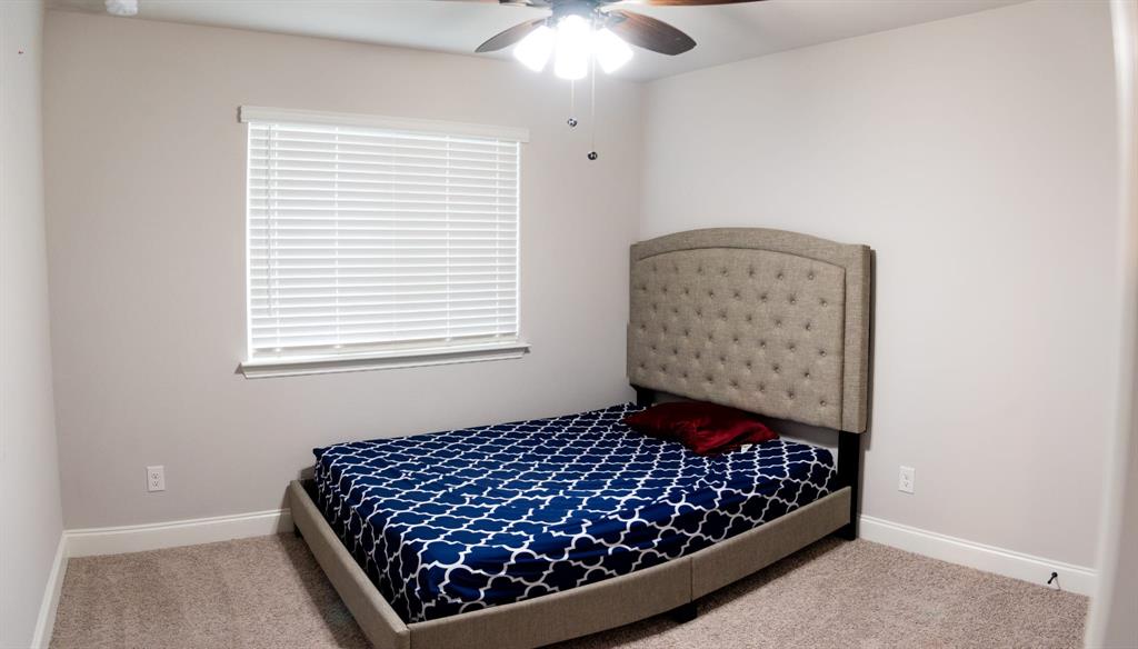 809 Woodview Court Anna, TX 75409 - Photo 23 of 25 a bed sitting in a bedroom next to a window