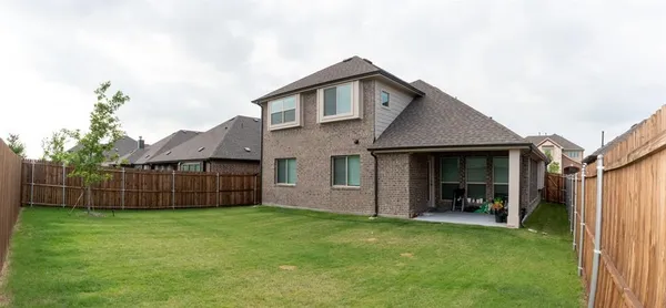 a view of a house with a yard and wooden fence