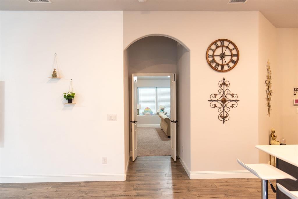 809 Woodview Court Anna, TX 75409 - Photo 6 of 25 a view of a hallway with wooden floor and a dining table