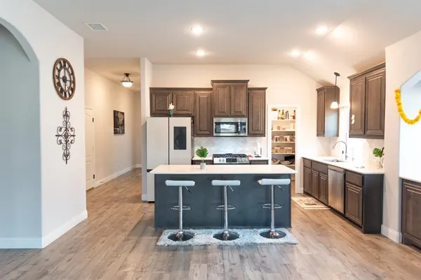 a kitchen with stainless steel appliances granite countertop a stove a sink a refrigerator and a refrigerator