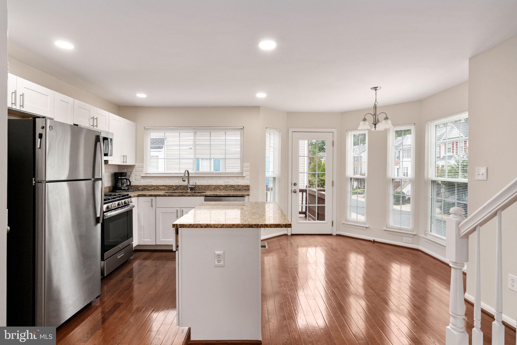 8548 Towne Manor Court Alexandria, VA 22309 - Photo 16 of 53 a kitchen with stainless steel appliances granite countertop a refrigerator a sink dishwasher a stove and a refrigerator with wooden floor