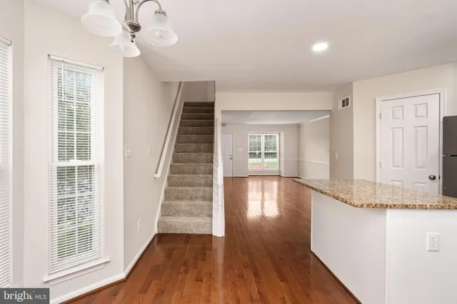 a view of a livingroom with wooden floor and staircase