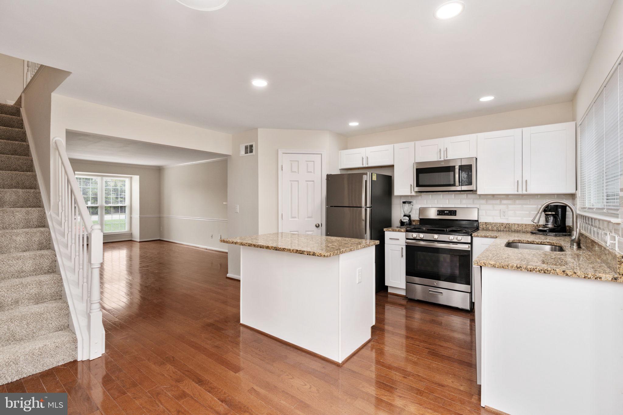 8548 Towne Manor Court Alexandria, VA 22309 - Photo 19 of 53 a kitchen with a refrigerator a stove top oven a sink and dishwasher