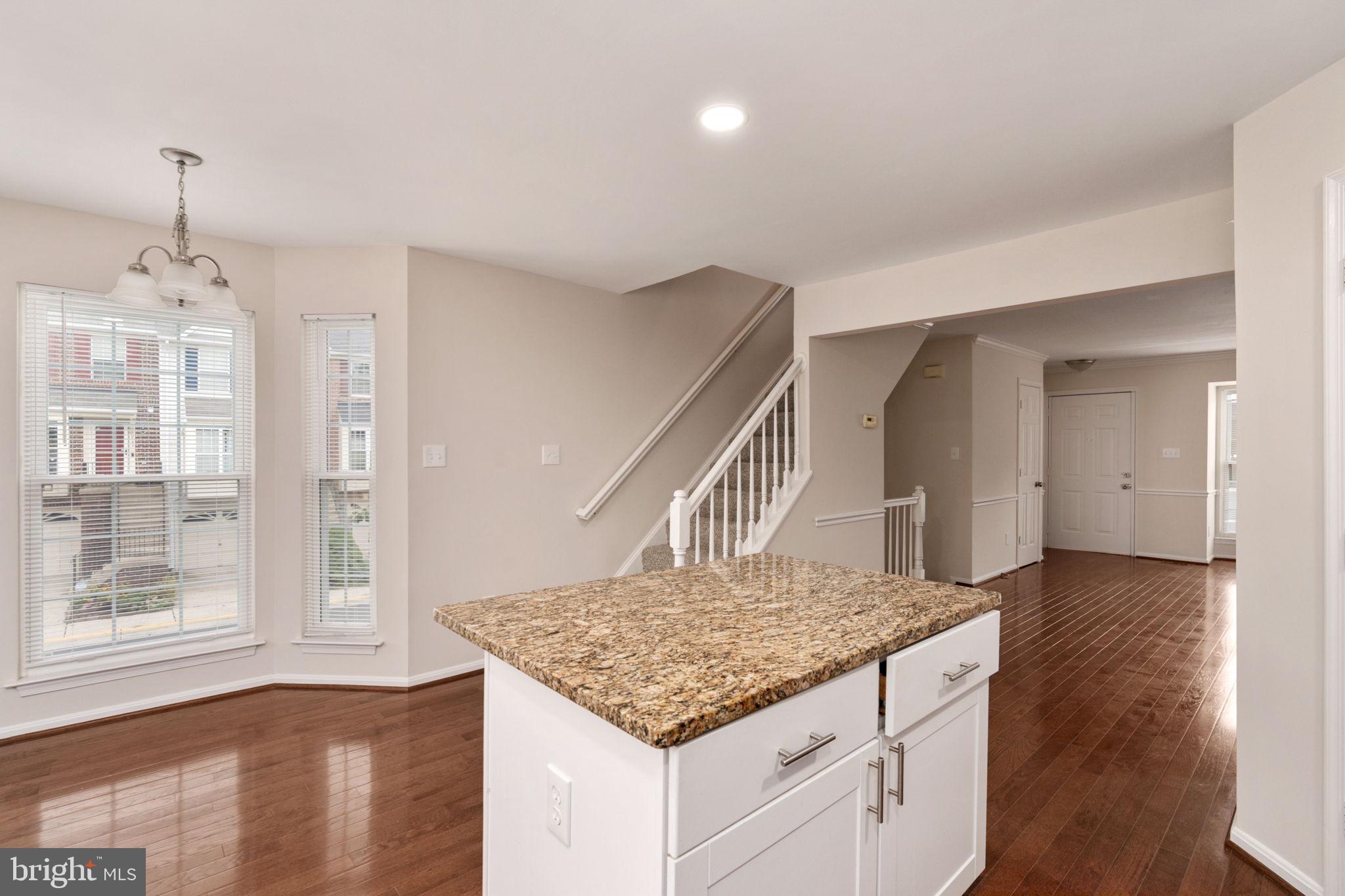 8548 Towne Manor Court Alexandria, VA 22309 - Photo 24 of 53 a kitchen with kitchen island granite countertop a stove and a wooden floors