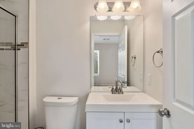 a bathroom with a shower sink vanity and toilet