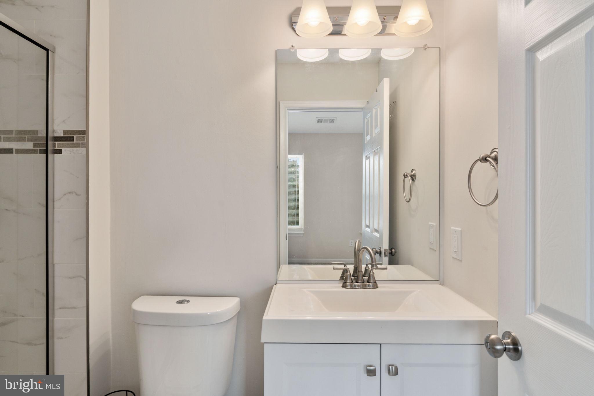 8548 Towne Manor Court Alexandria, VA 22309 - Photo 31 of 53 a bathroom with a sink a toilet and a mirror
