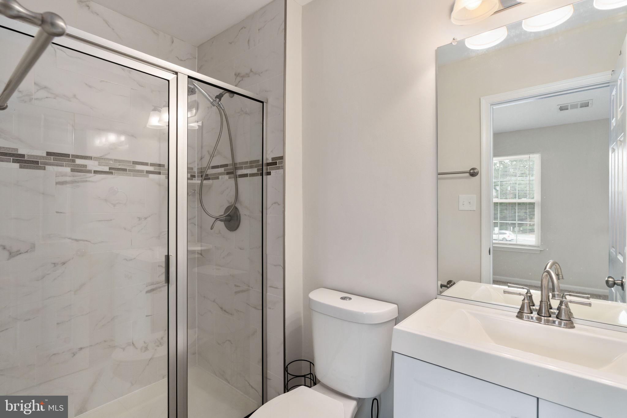 8548 Towne Manor Court Alexandria, VA 22309 - Photo 32 of 53 a bathroom with a shower sink vanity and toilet