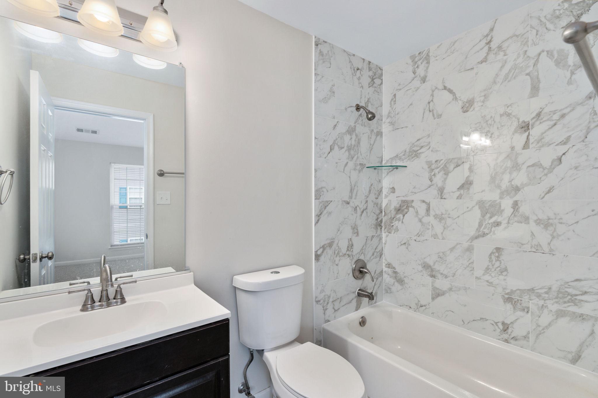 8548 Towne Manor Court Alexandria, VA 22309 - Photo 38 of 53 a bathroom with a sink toilet a mirror and shower