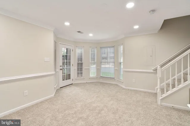 a view of a kitchen with refrigerator and white cabinets