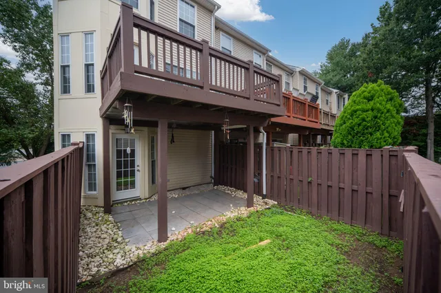 a view of a house with backyard and wooden fence