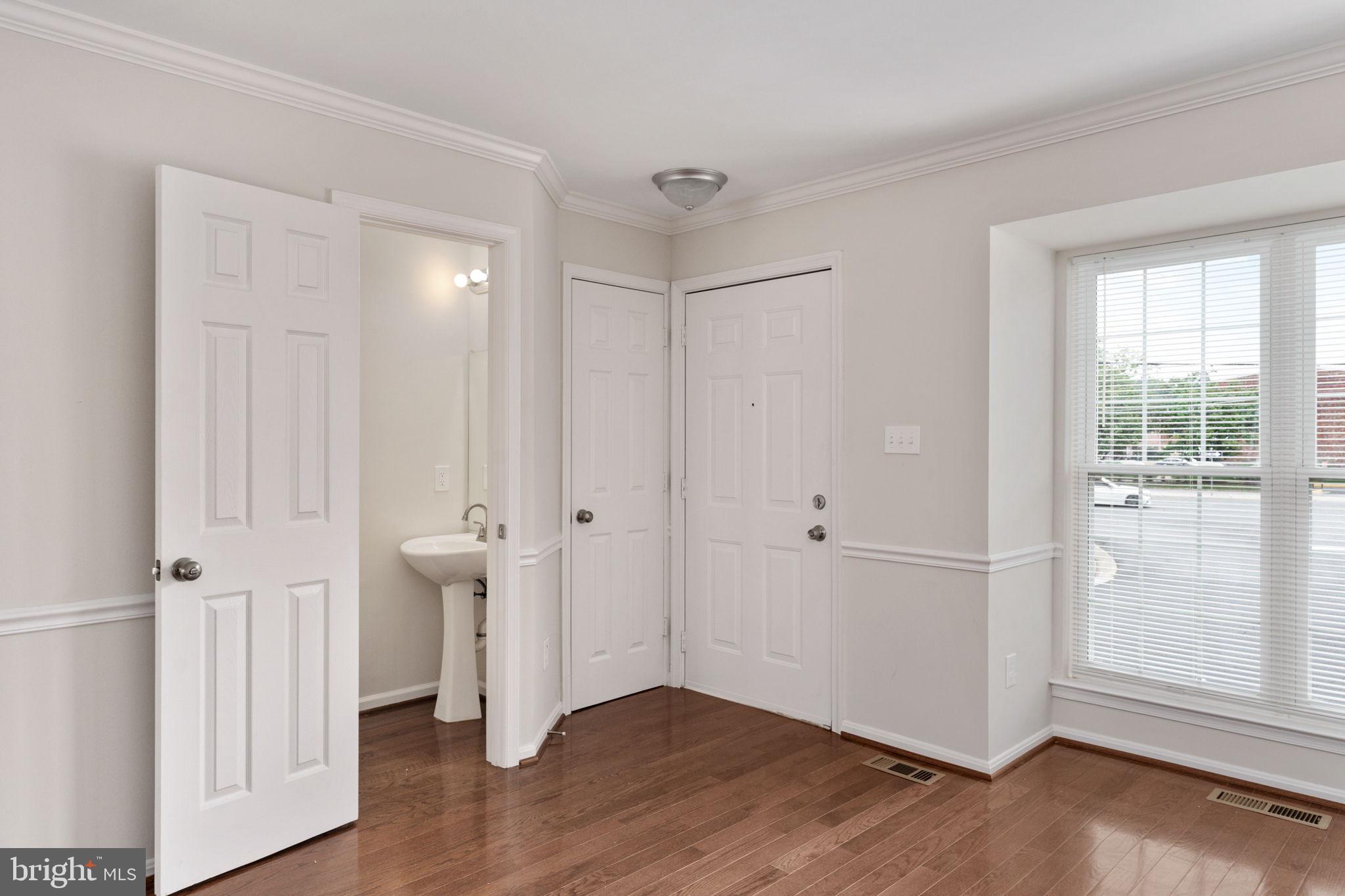 8548 Towne Manor Court Alexandria, VA 22309 - Photo 9 of 53 an empty room with wooden floor door and windows