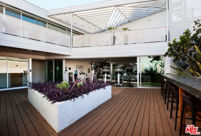 a view of a chairs and table in a patio with a barbeque grill