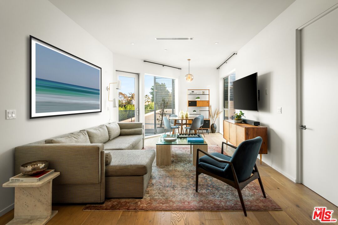 1030 North Kings Road, Unit 407 West Hollywood, CA 90069 - Photo 2 of 19 a living room with furniture and a flat screen tv
