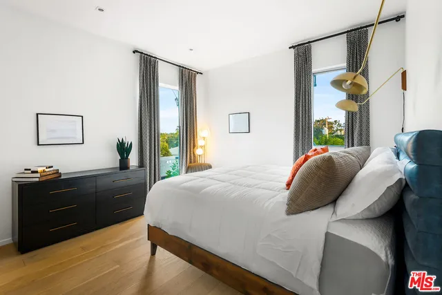 a bedroom with a bed window and a dresser