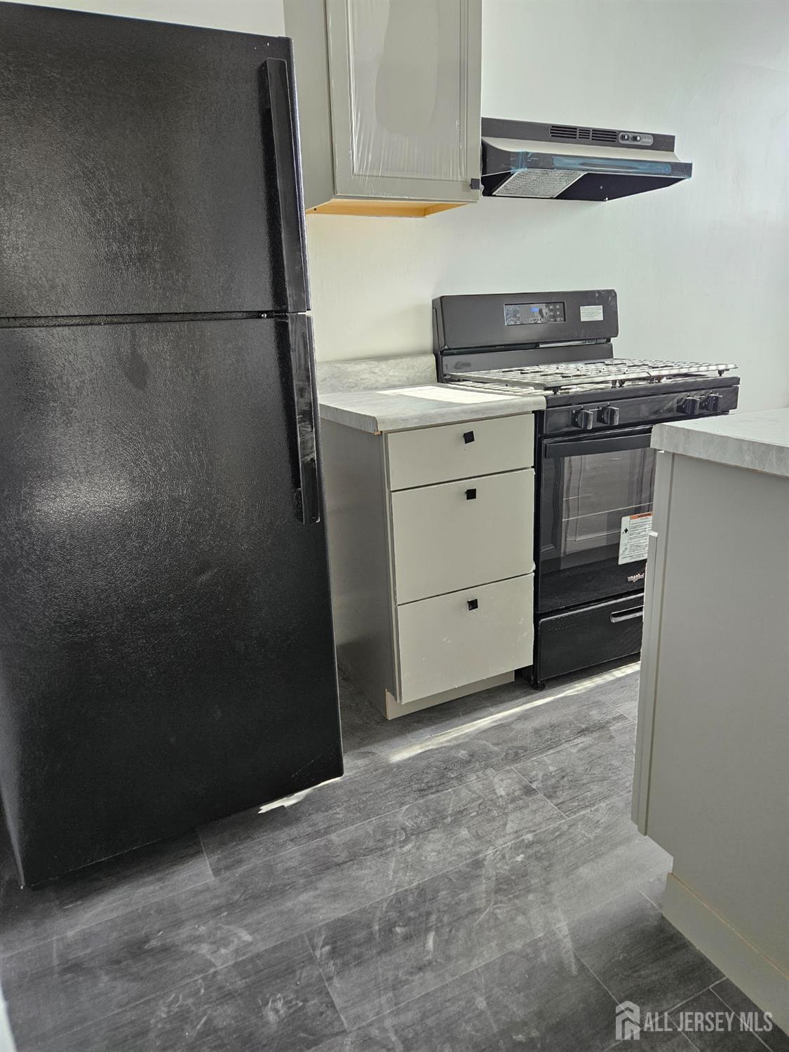 110 Market Street, Unit 3E Perth Amboy, NJ 08861 - Photo 2 of 5 a kitchen with a stove and a refrigerator