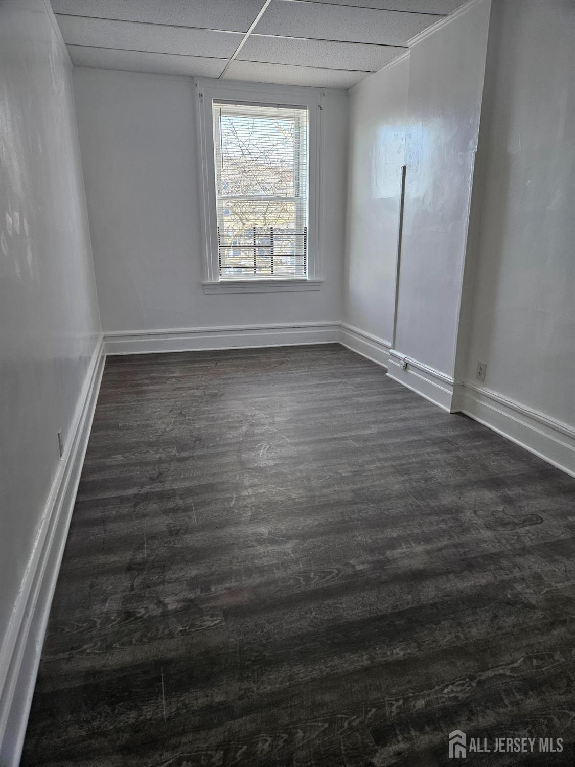 110 Market Street, Unit 3E Perth Amboy, NJ 08861 - Photo 4 of 5 an empty room with wooden floor and windows