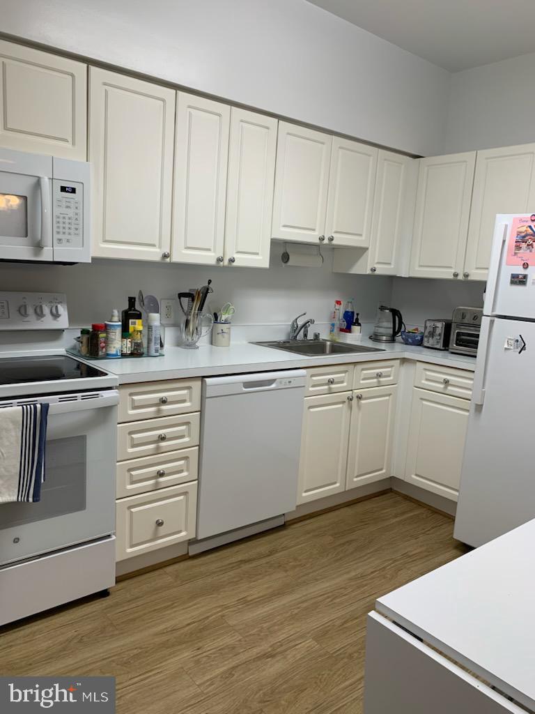 3200 North Leisure World Boulevard, Unit 514 Silver Spring, MD 20906 - Photo 9 of 26 a kitchen with white cabinets stainless steel appliances and sink
