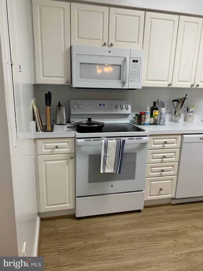 3200 North Leisure World Boulevard, Unit 514 Silver Spring, MD 20906 - Photo 10 of 26 a kitchen with stainless steel appliances granite countertop a stove a sink and white cabinets