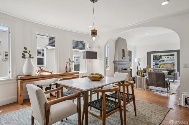 a kitchen with stainless steel appliances granite countertop a dining table chairs refrigerator and cabinets