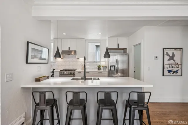 a kitchen with white cabinets and stainless steel appliances