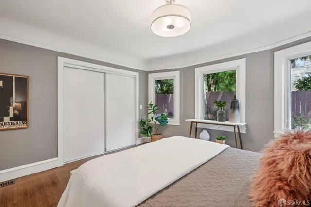 a bedroom with a bed and wooden floor