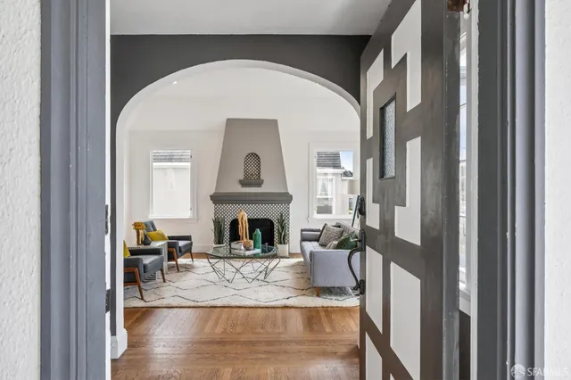 a view of a hallway with wooden floor and a living room