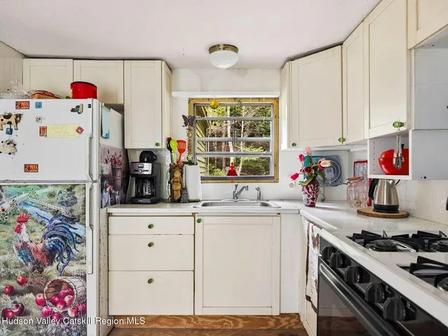 a kitchen with granite countertop a white stove top oven sink and cabinets