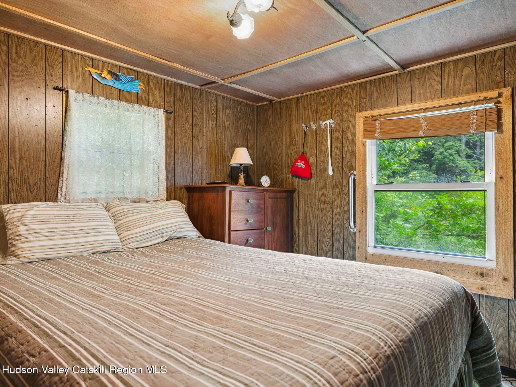 325 Brand Road Conesville, NY 12076 - Photo 18 of 36 a bedroom with a large bed and a chandelier