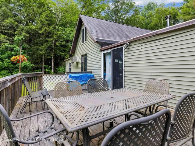 a view of a patio with table and chairs with wooden floor and fence