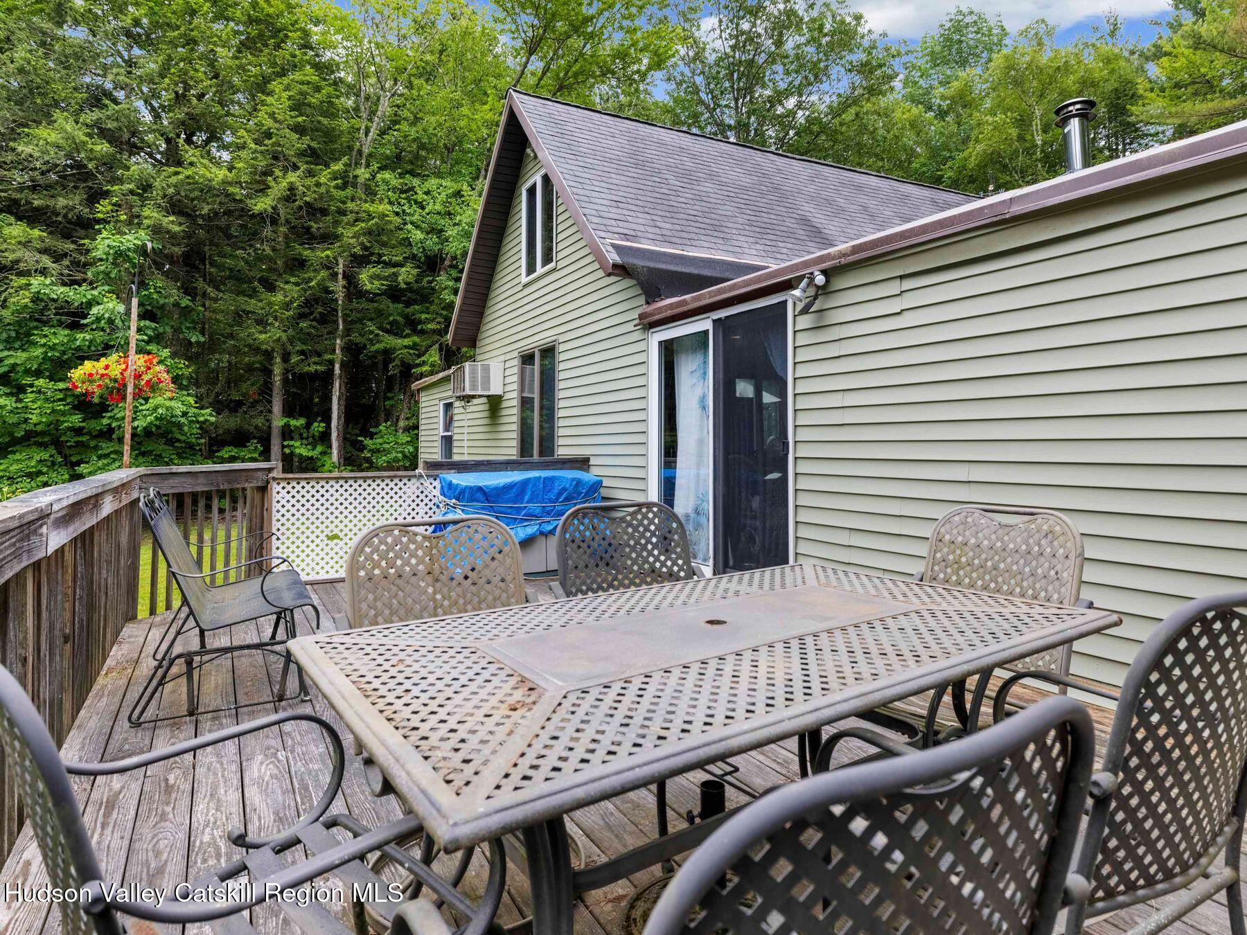325 Brand Road Conesville, NY 12076 - Photo 25 of 36 a view of a patio with table and chairs with wooden floor and fence