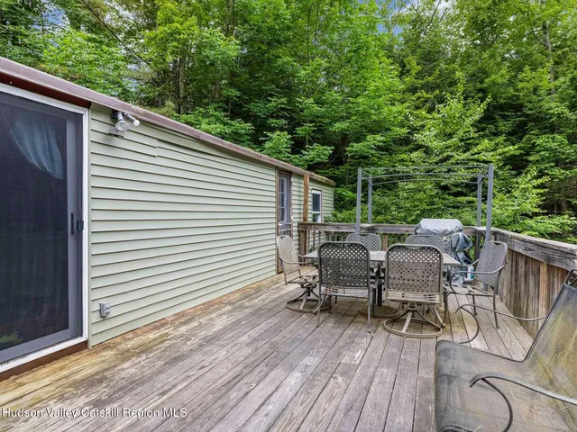a view of deck with table and chairs a barbeque with wooden floor and fence