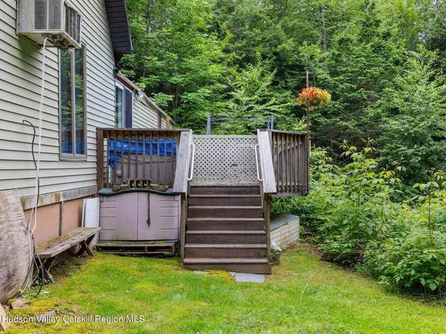 a view of a backyard with plants and a small cabin