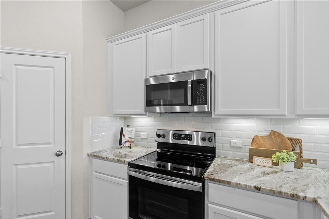 1932 Viva Road Bryan, TX 77807 - Photo 9 of 38 Kitchen with appliances with stainless steel finishes, tasteful backsplash, and white cabinetry