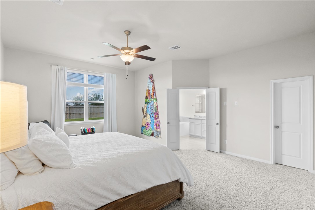 1932 Viva Road Bryan, TX 77807 - Photo 18 of 38 Carpeted bedroom featuring ceiling fan and connected bathroom