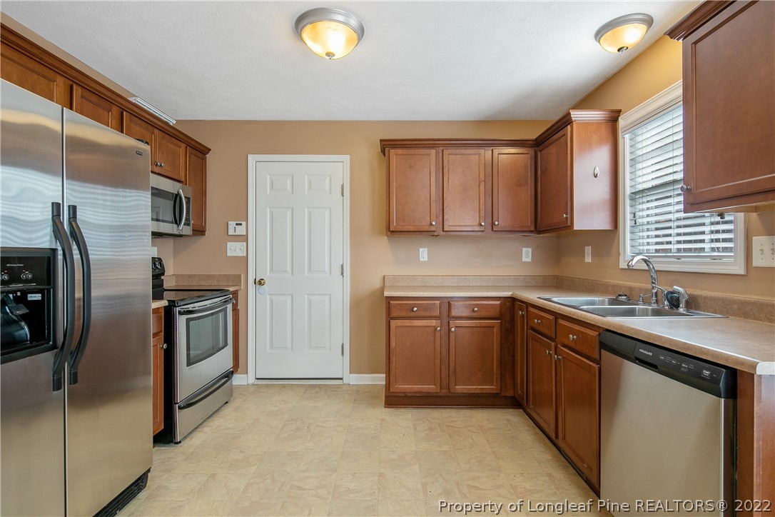 38 Rockingham Street Spring Lake, NC 28390 - Photo 18 of 50 a kitchen with stainless steel appliances granite countertop a stove a sink and a refrigerator