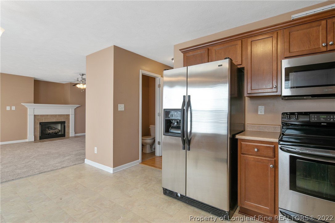 38 Rockingham Street Spring Lake, NC 28390 - Photo 21 of 50 a kitchen with stainless steel appliances granite countertop a refrigerator a stove and a sink with wooden floor