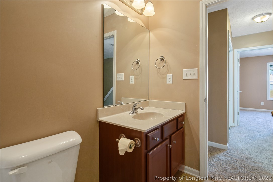 38 Rockingham Street Spring Lake, NC 28390 - Photo 37 of 50 a bathroom with a granite countertop sink a toilet and a mirror