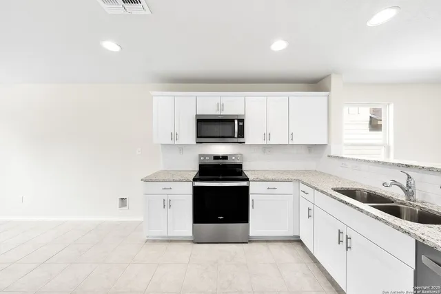 a kitchen with a stove top oven and cabinets