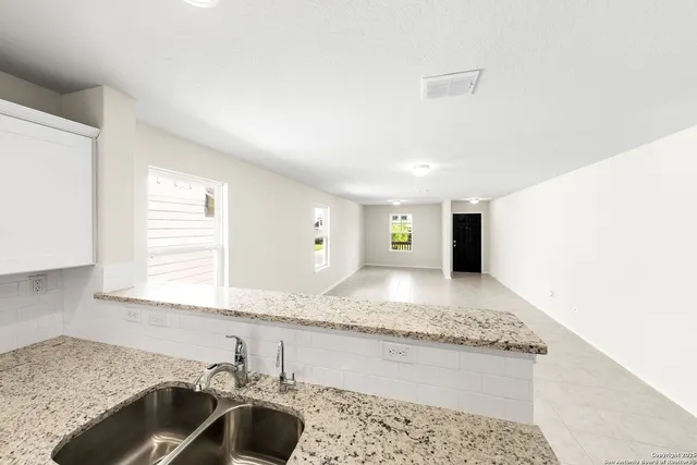 a bathroom with a granite countertop sink and a bathtub