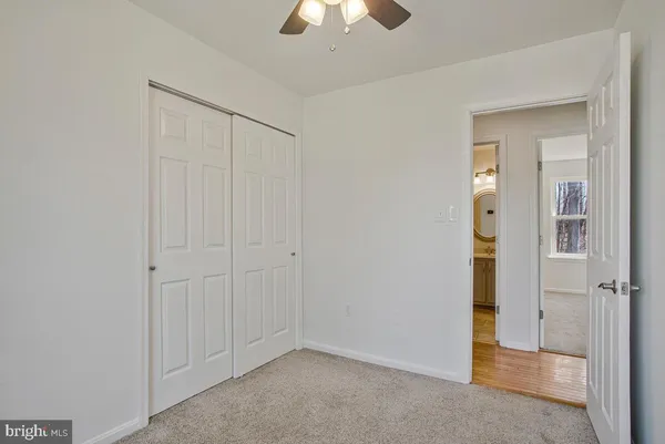 an empty room with closet and a chandelier fan