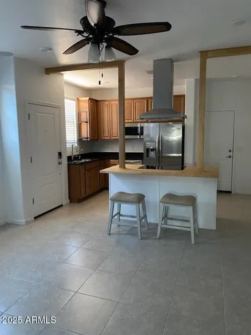 a room with furniture a flat screen tv and kitchen view