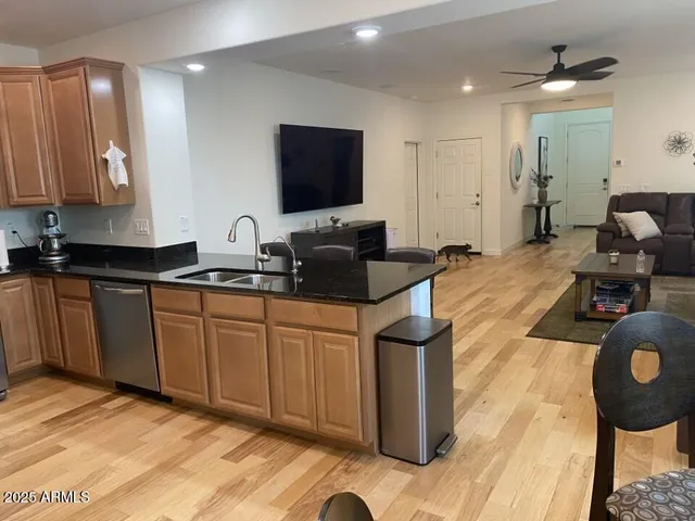 a kitchen with a sink and a stove top oven with wooden floor