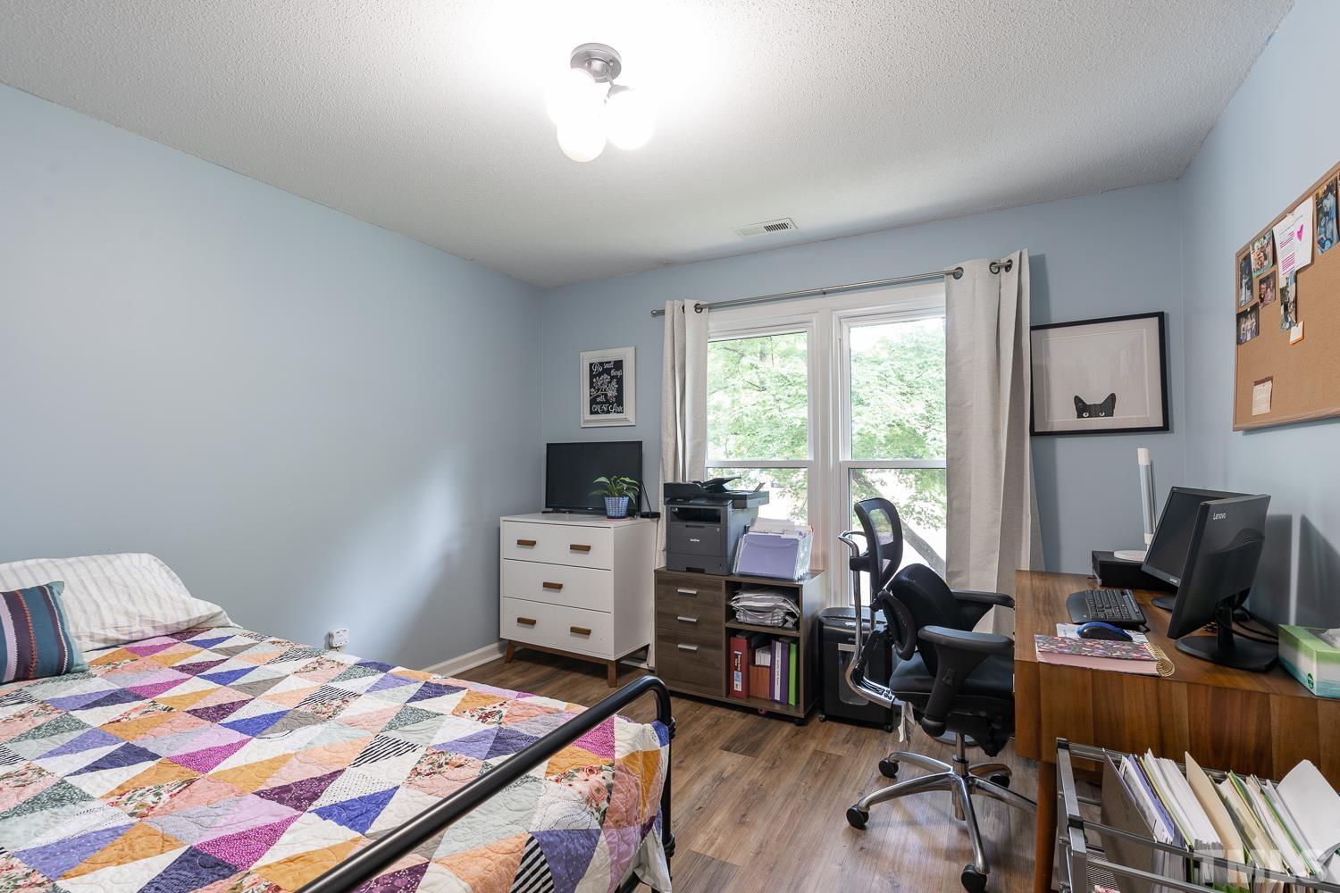 8112 Bentwood Place Raleigh, NC 27615 - Photo 11 of 24 a bedroom with a bed and a desk