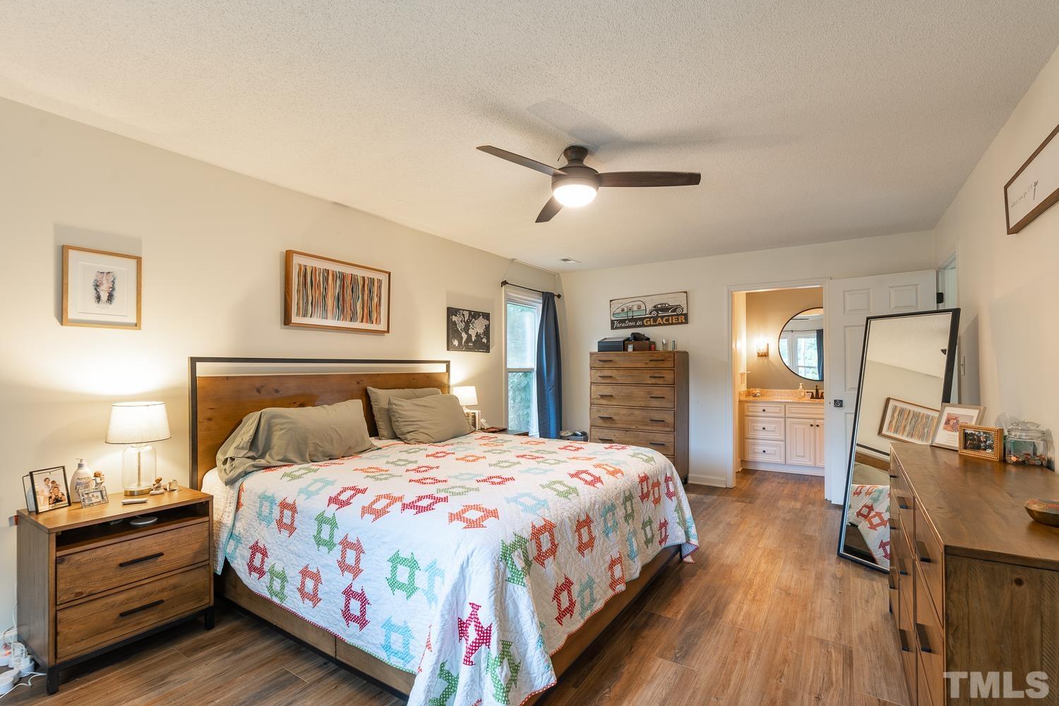 8112 Bentwood Place Raleigh, NC 27615 - Photo 15 of 24 a spacious bedroom with a bed a dresser and wooden floor