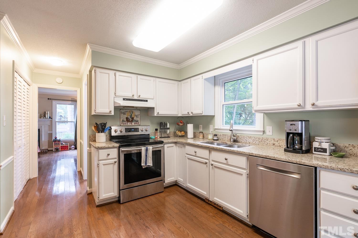 8112 Bentwood Place Raleigh, NC 27615 - Photo 18 of 24 a kitchen with stainless steel appliances granite countertop a stove a sink dishwasher and a microwave oven with wooden floor